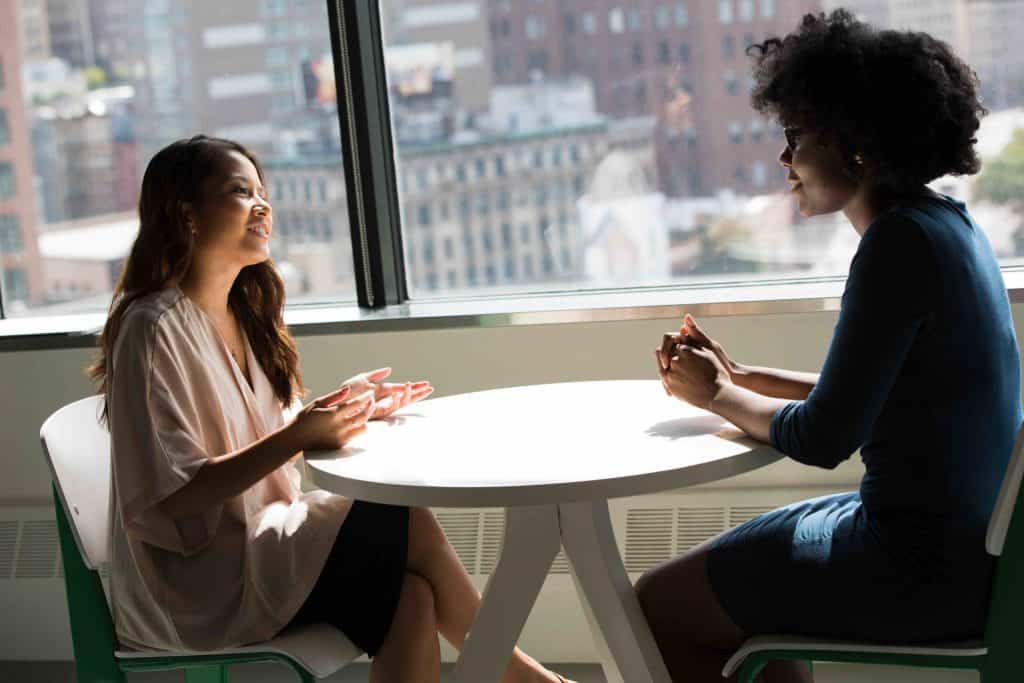 deux femmes en discussion dans la cafétaria d'une entreprise